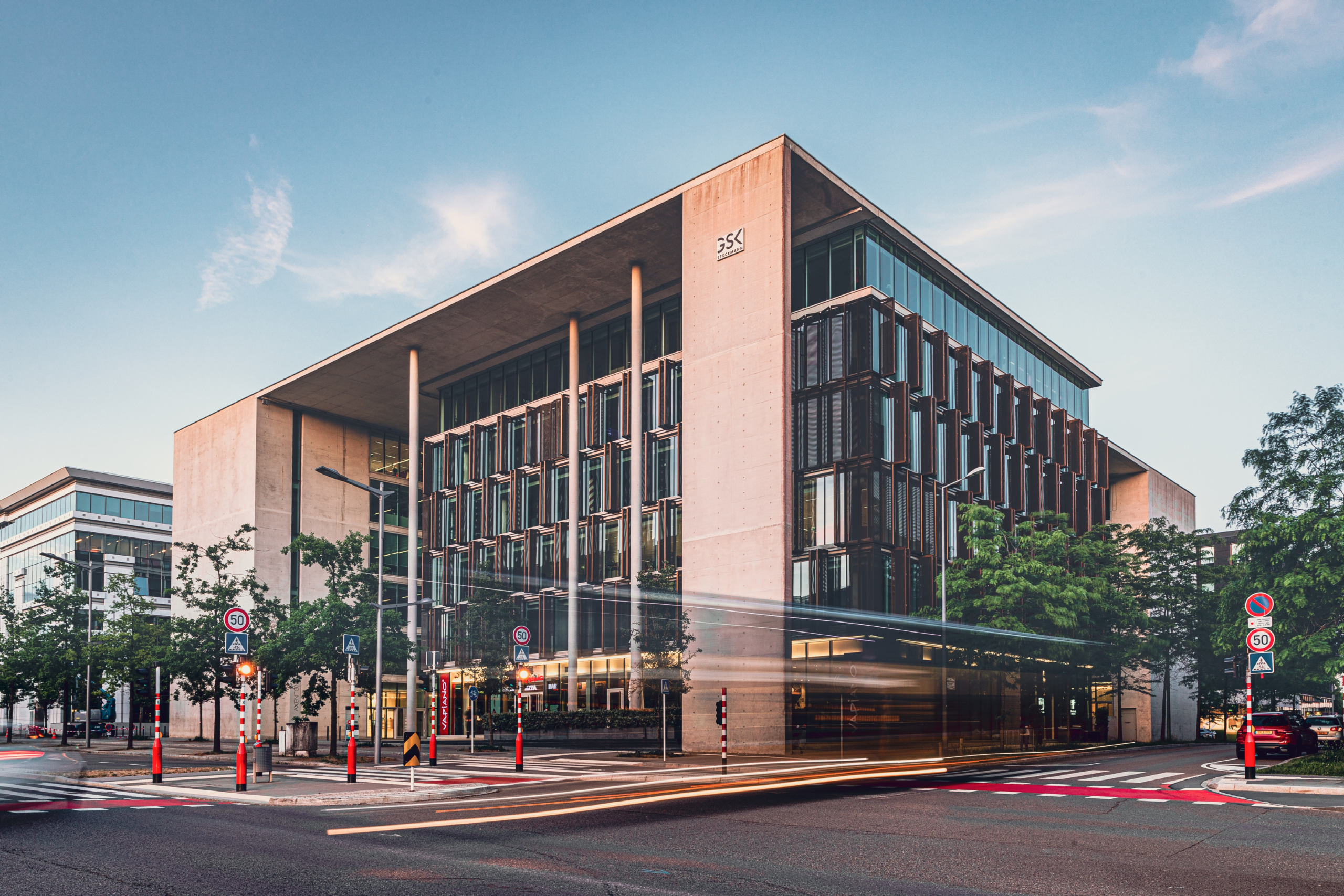 Exterior view of the GSK Stockmann Luxembourg office building at dusk with light trails from passing traffic