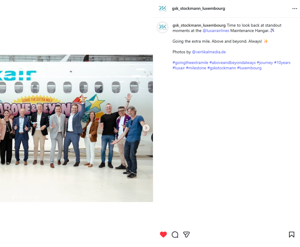 Photo of GSK Stockmann colleagues waving in front of the Luxair anniversary aircraft in the maintenance hangar