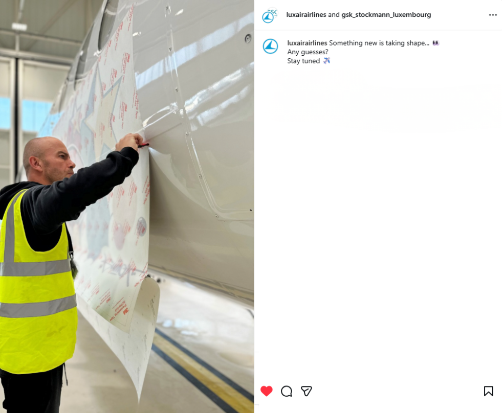 Screenshot of an Instagram post showing a worker applying the anniversary livery design to the Luxair aircraft