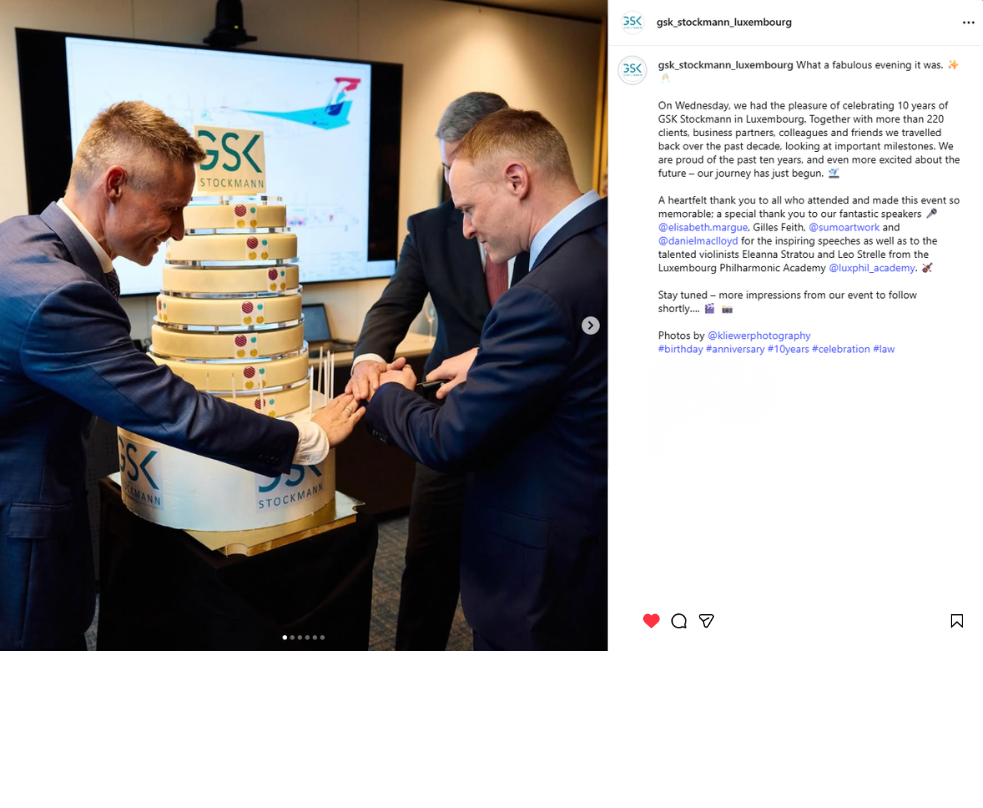 Photo of two men cutting a multi-tier anniversary cake at the GSK Stockmann celebration